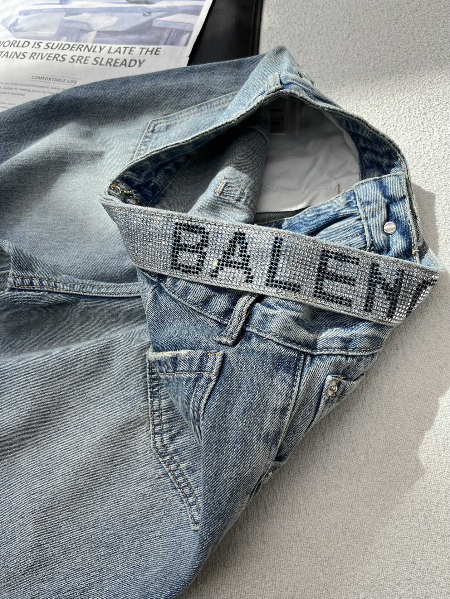 Классические джинсы Balenciaga 2403 с едва заметной надписью из страз.