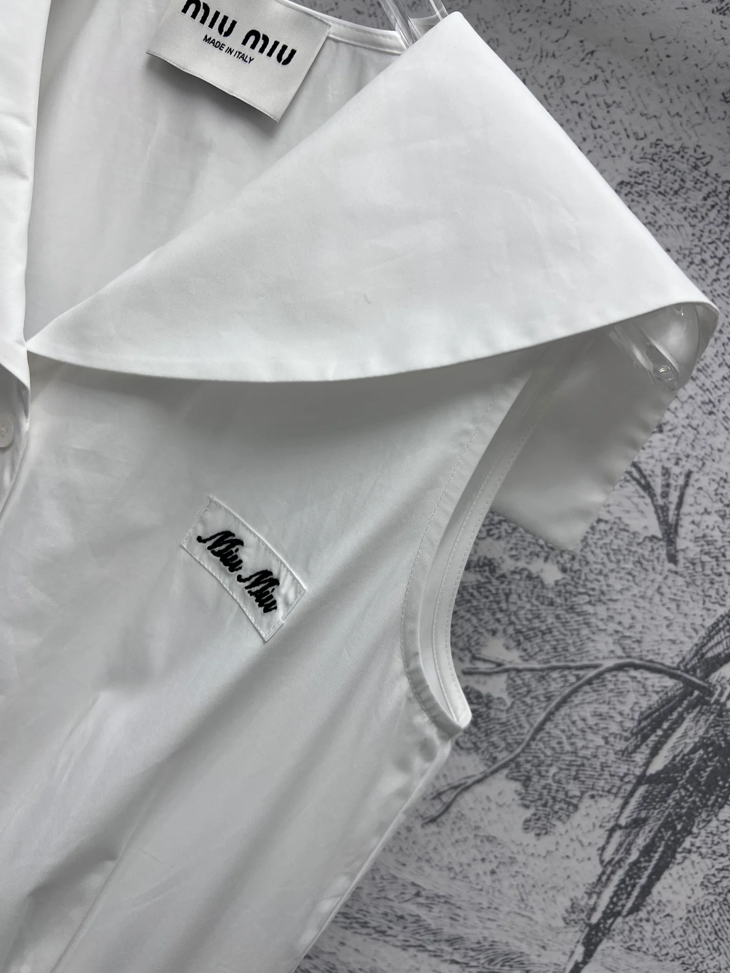 Платье Miu Miu в стиле преппи из коллекции Весна/Лето 2024 с воротником-шалью и пуговицами — белое.