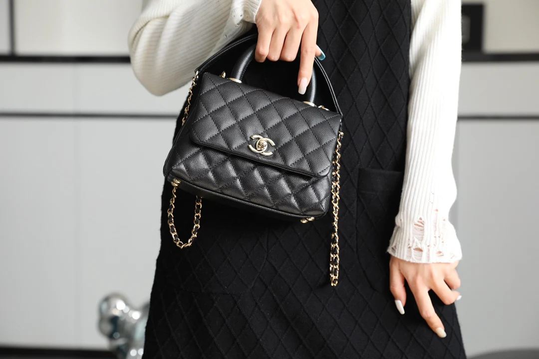 Мини-сумка Chanel Coco Handle — черная кожа с золотистой пряжкой.