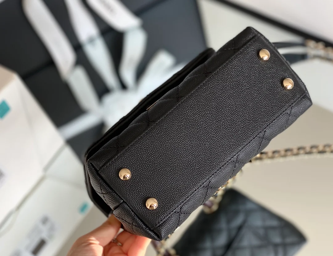 Мини-сумка Chanel Coco Handle — черная кожа с золотистой пряжкой.