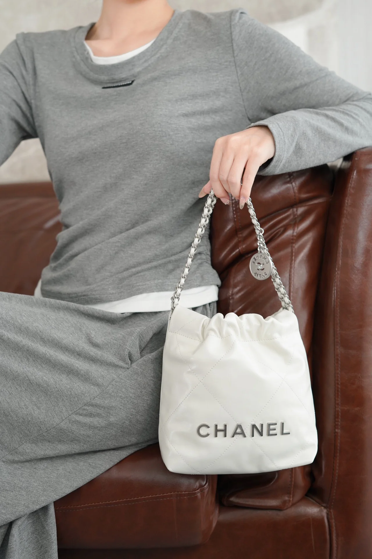 Мини-сумка Chanel 23s 22bag белого цвета с серебристой фурнитурой.