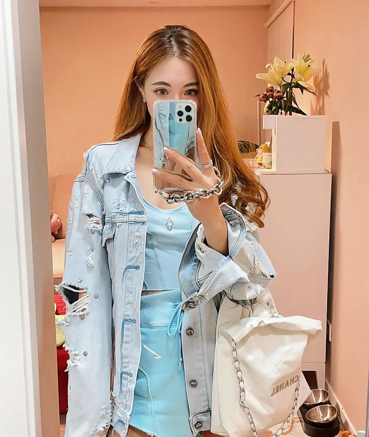 Сумочка Chanel No. 22 — маленькая, белая, серебристая.