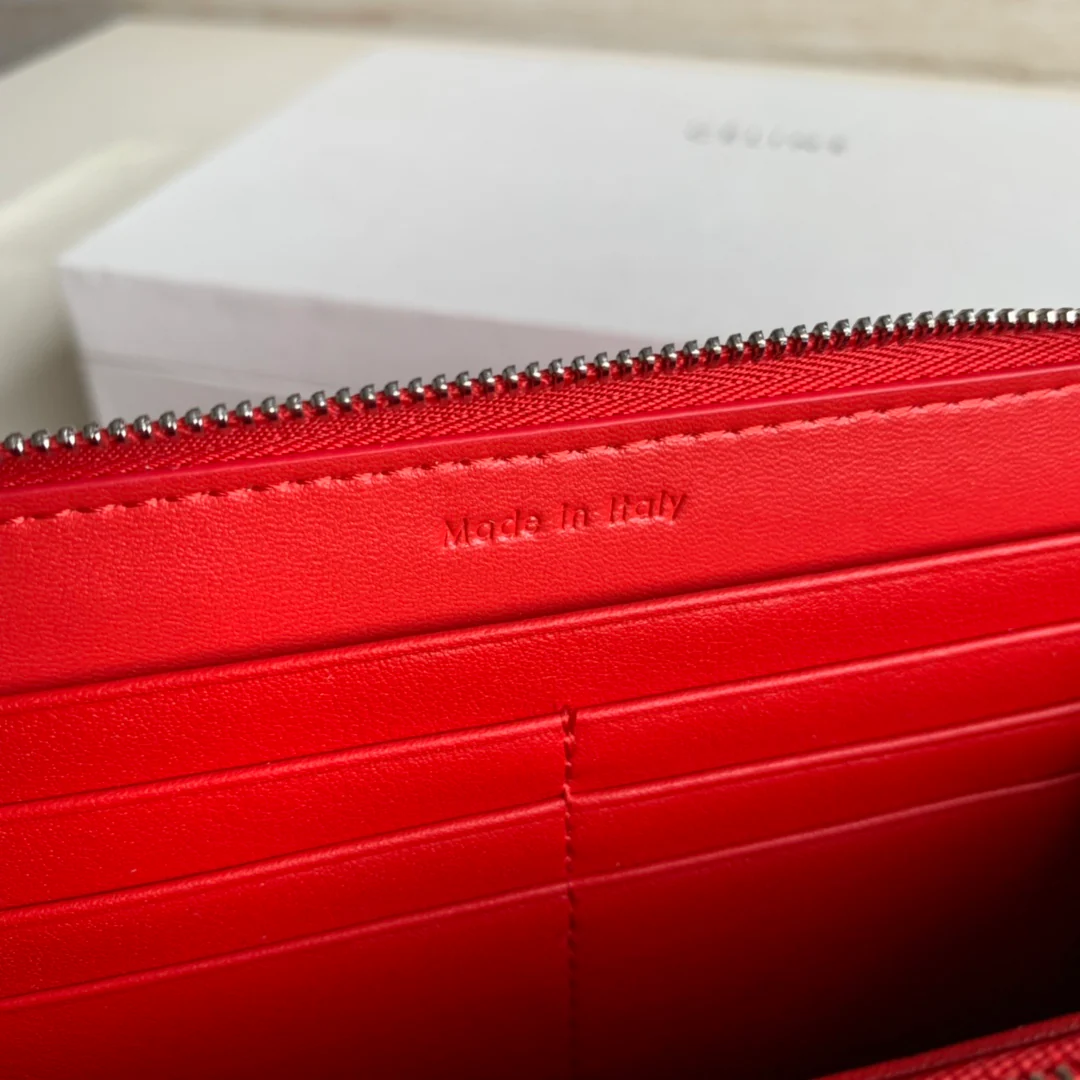 Кошелек Celine с длинной молнией — оранжево-красный узор в виде ряби на воде.