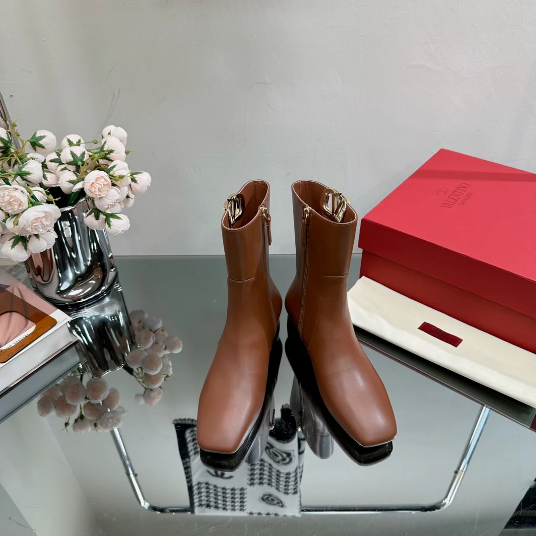 Новинка сезона осень/зима 2023 от Valentino — ботильоны на массивном каблуке с небольшим V-образным логотипом — кофейного цвета.