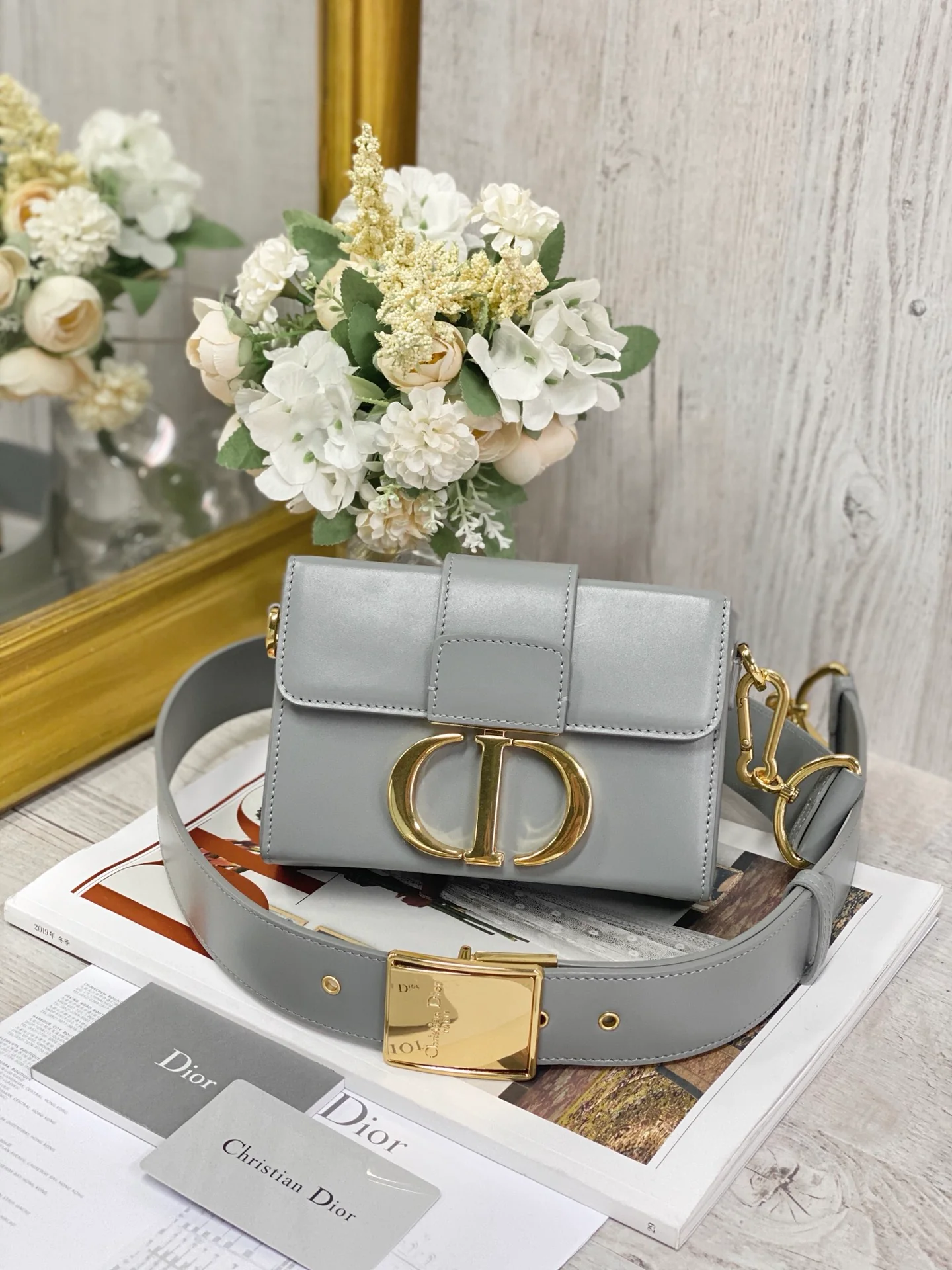 Миниатюрная шкатулка Dior Montaigne из гладкой кожи с золотой пряжкой, 17,5 см, серая.