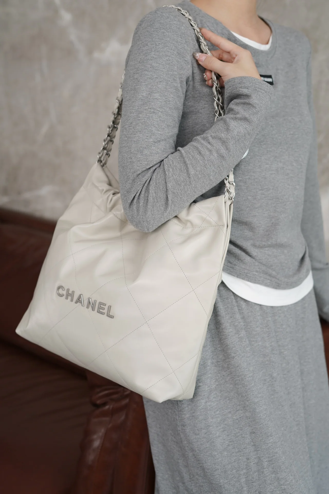 Маленькая белая сумочка Chanel с серебряной пряжкой на задней части.