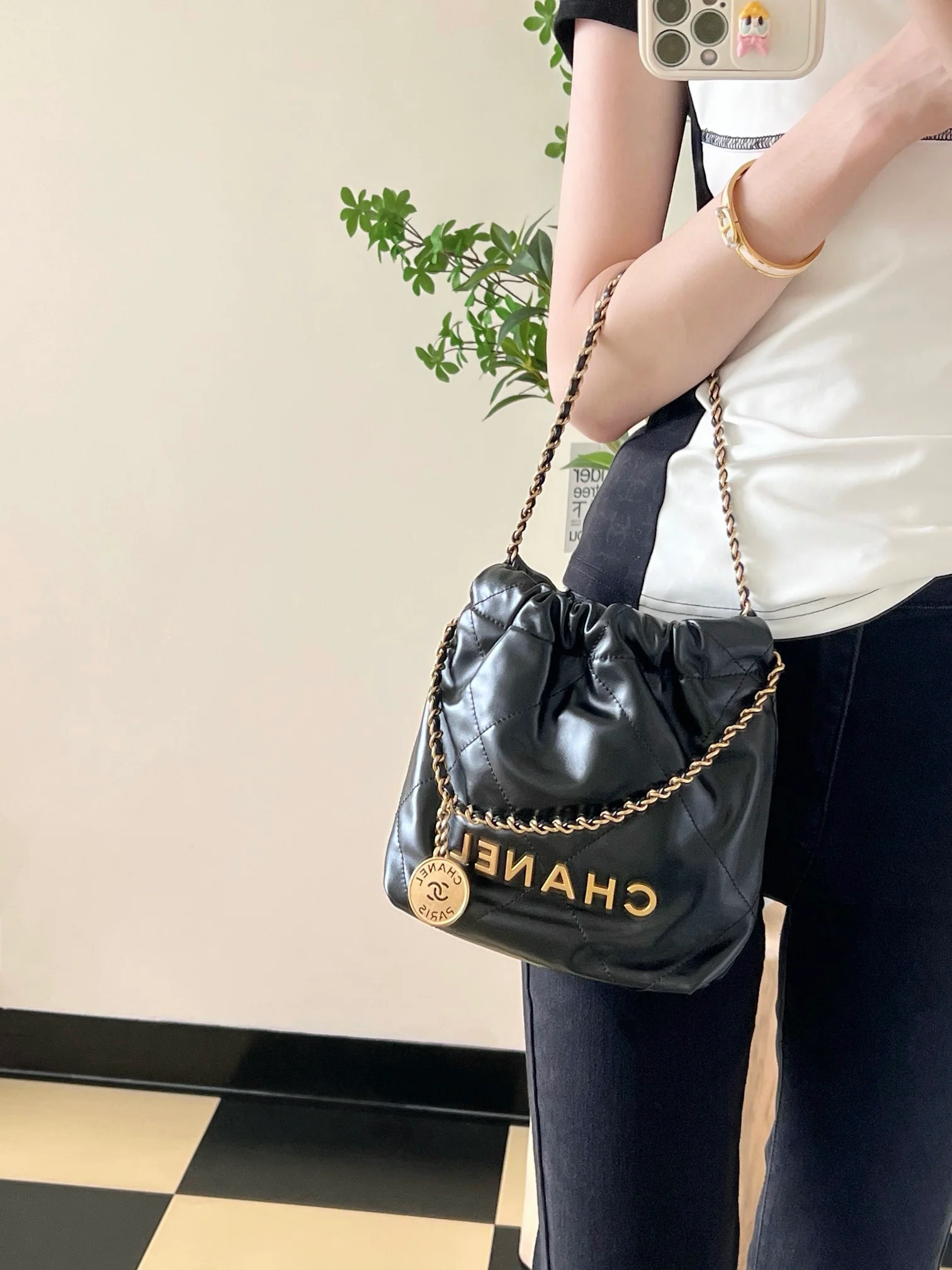 Мини-сумочка Chanel 22 – черная с золотой фурнитурой.