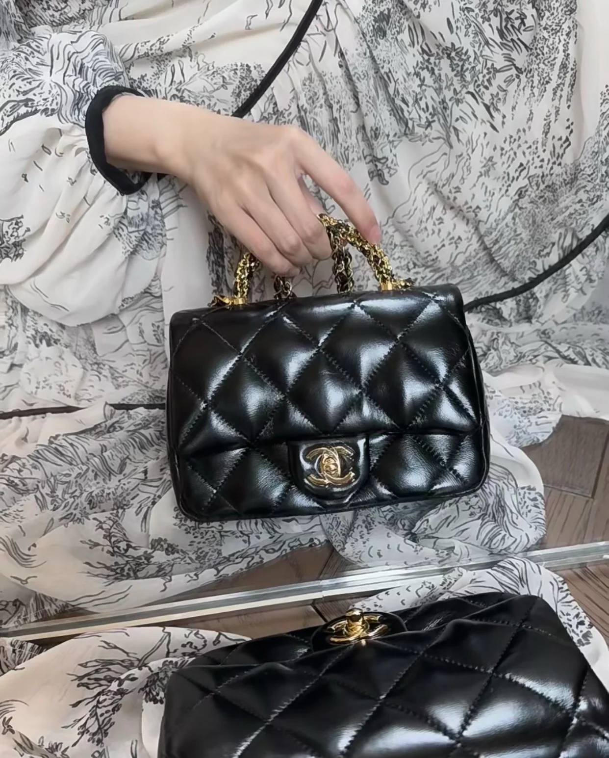 Маленькая черная сумка Chanel с клапаном и поворотной ручкой.