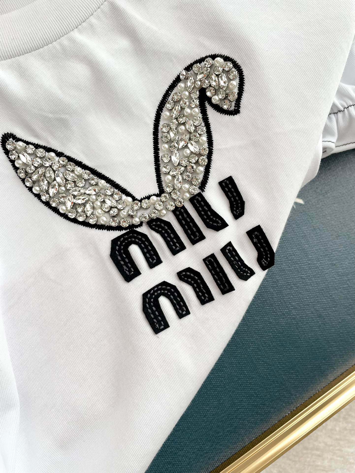 Miu Miu-2404 - Футболка с коротким рукавом, пышными рукавами, украшенная заячьими ушками и заклепками, с круглым вырезом и надписью.