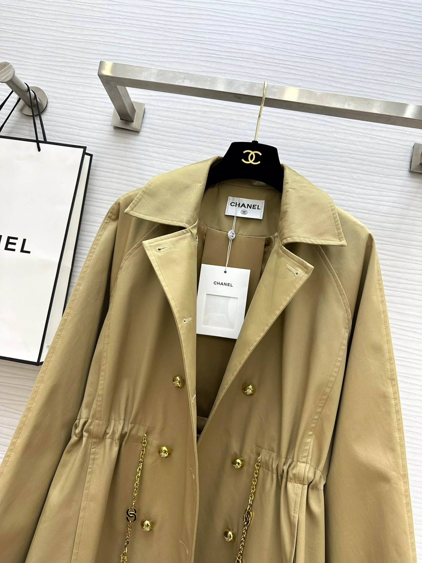 Новая коллекция Chanel весна/лето 2024: двубортный тренч, украшенный цепочками.