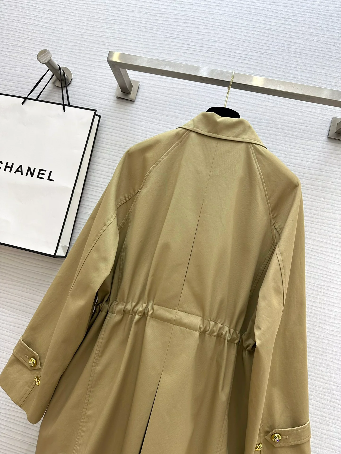 Новая коллекция Chanel весна/лето 2024: двубортный тренч, украшенный цепочками.