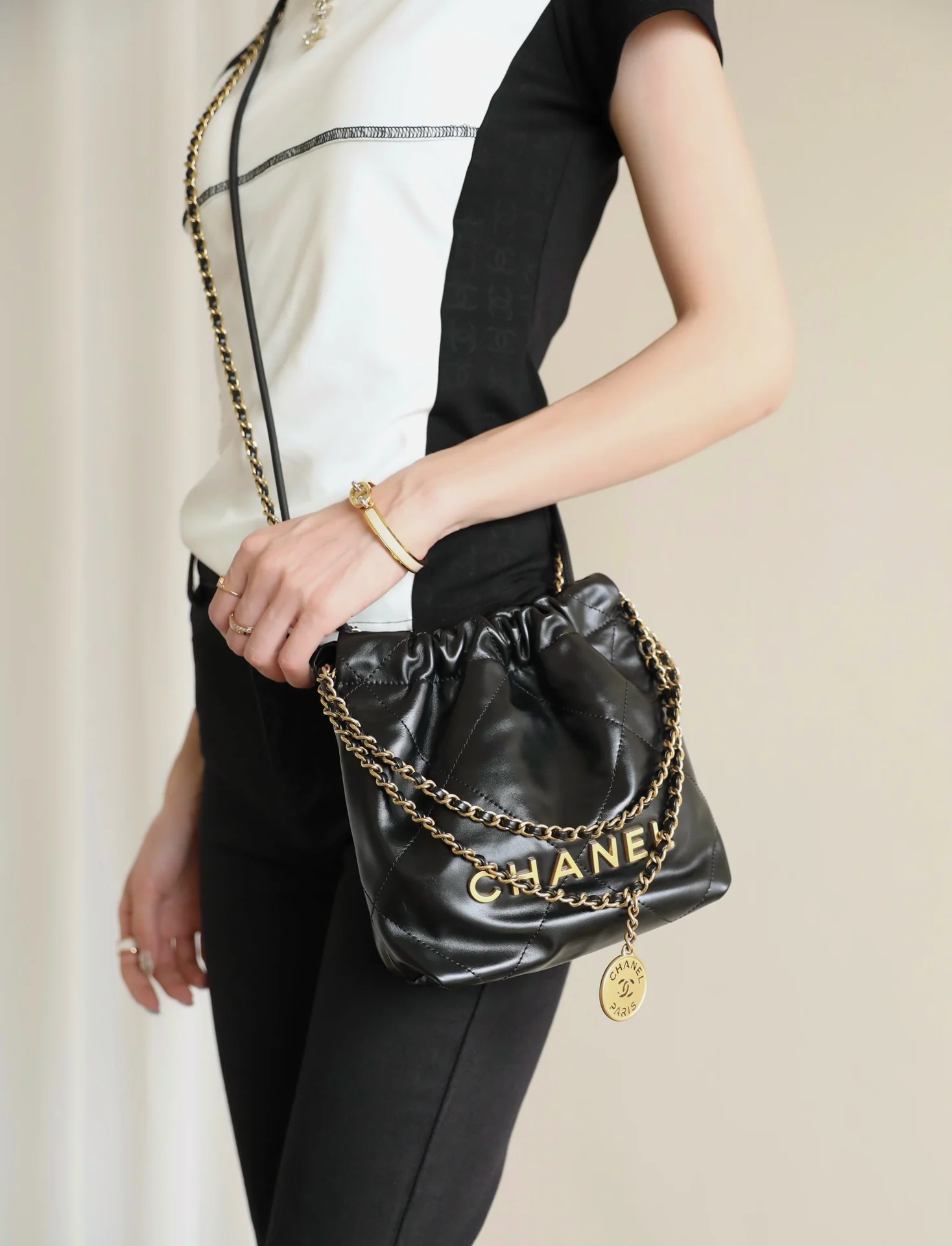 Мини-сумочка Chanel 22 – черная с золотой фурнитурой.