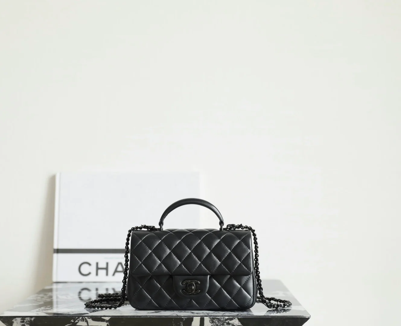 Мини-сумочка Chanel 25p-CF с клапаном — черная с черной пряжкой.