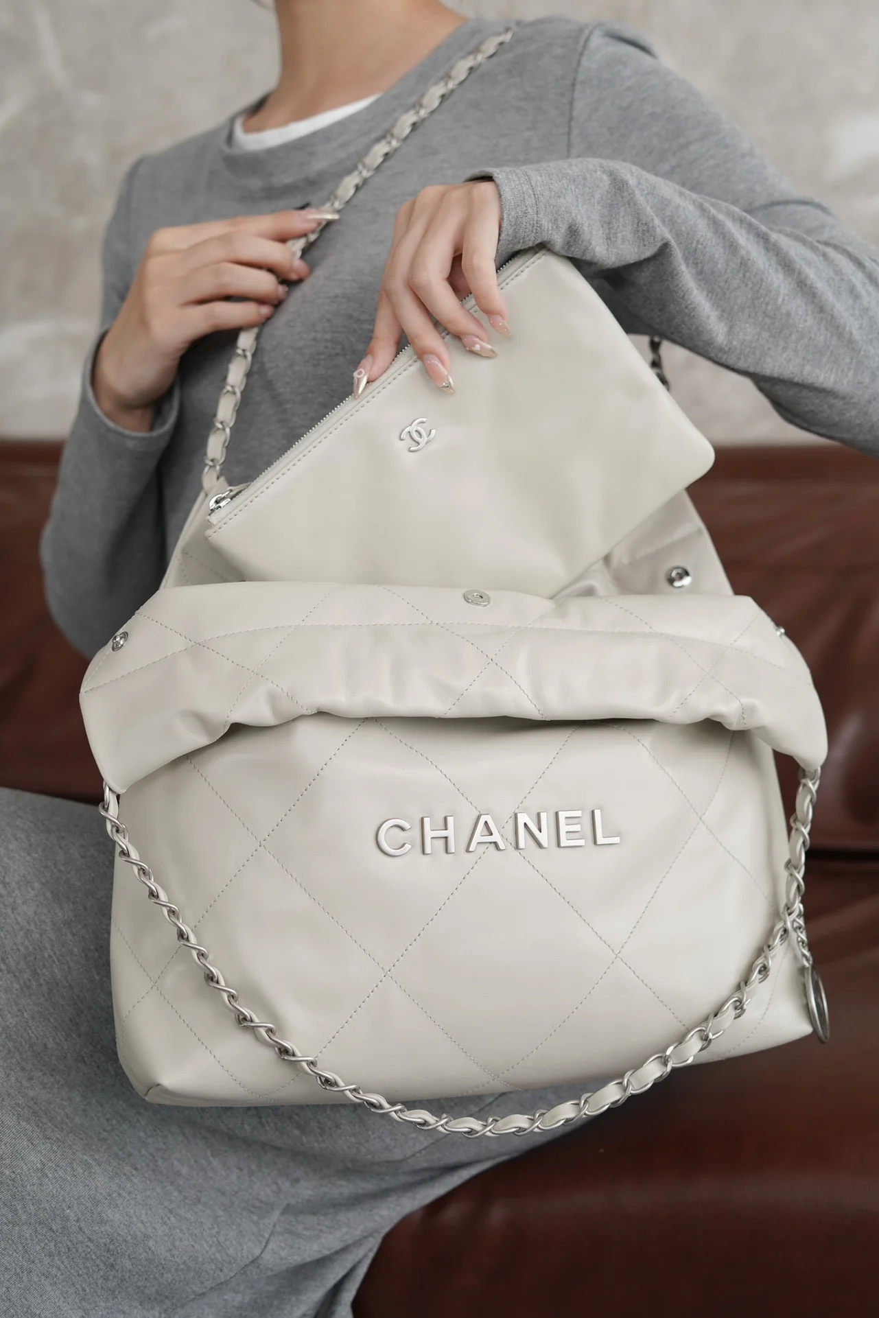 Маленькая белая сумочка Chanel с серебряной пряжкой на задней части.