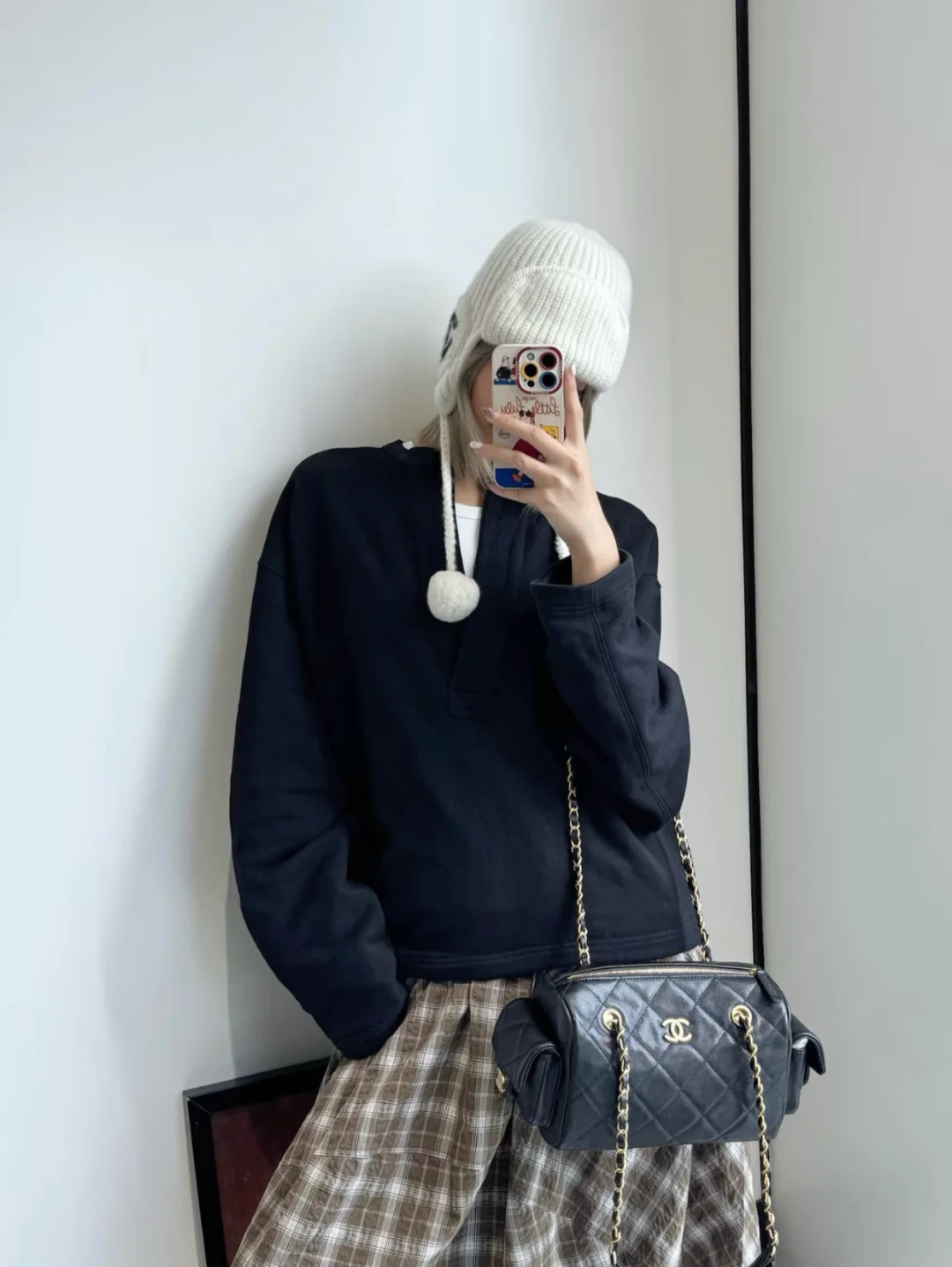 Сумка-боулинг Chanel 25k с двумя карманами — черная кожа с золотой пряжкой и маленьким шариком.