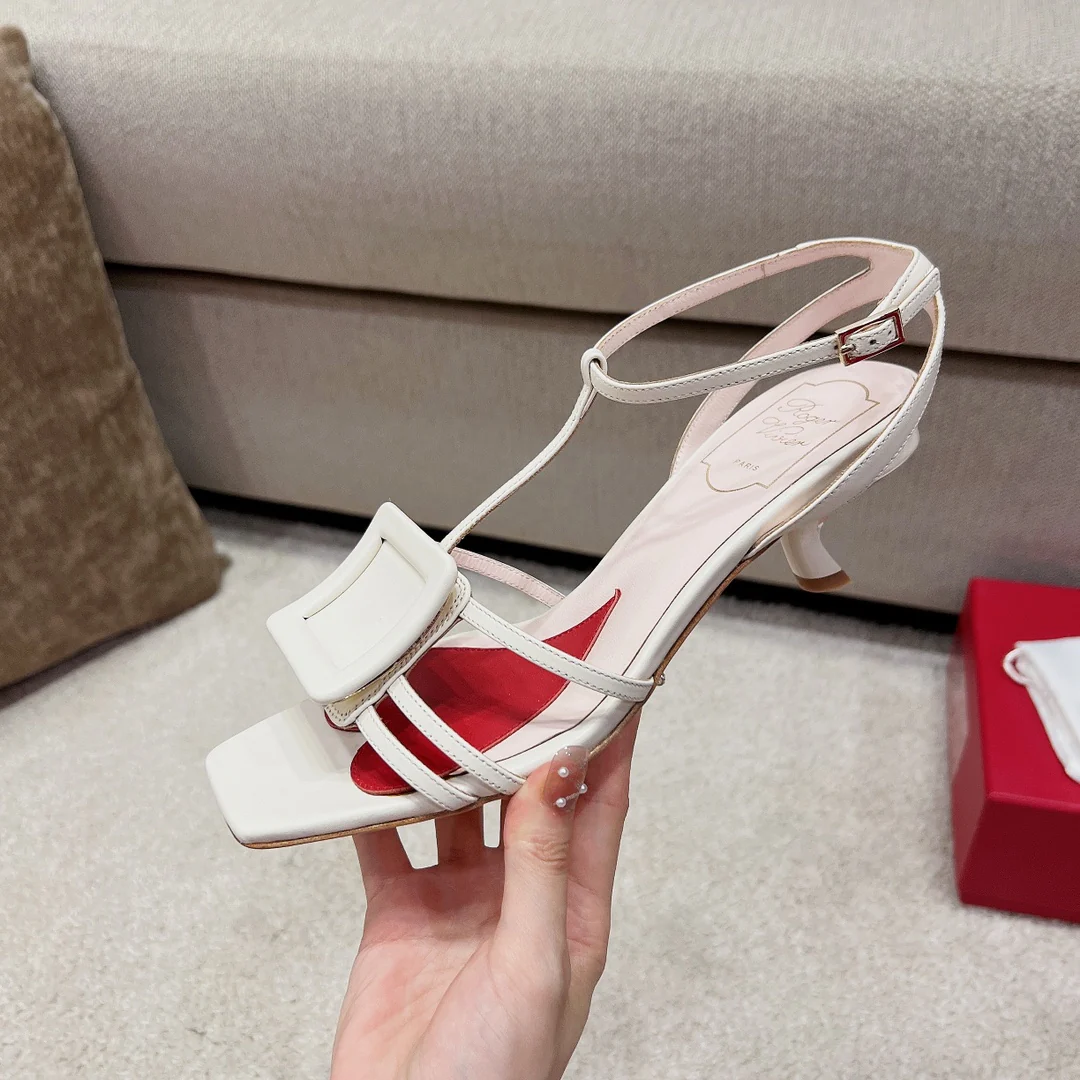 Сандалии RV Shoes - белые, с квадратной пряжкой, на низком каблуке и ремешками.