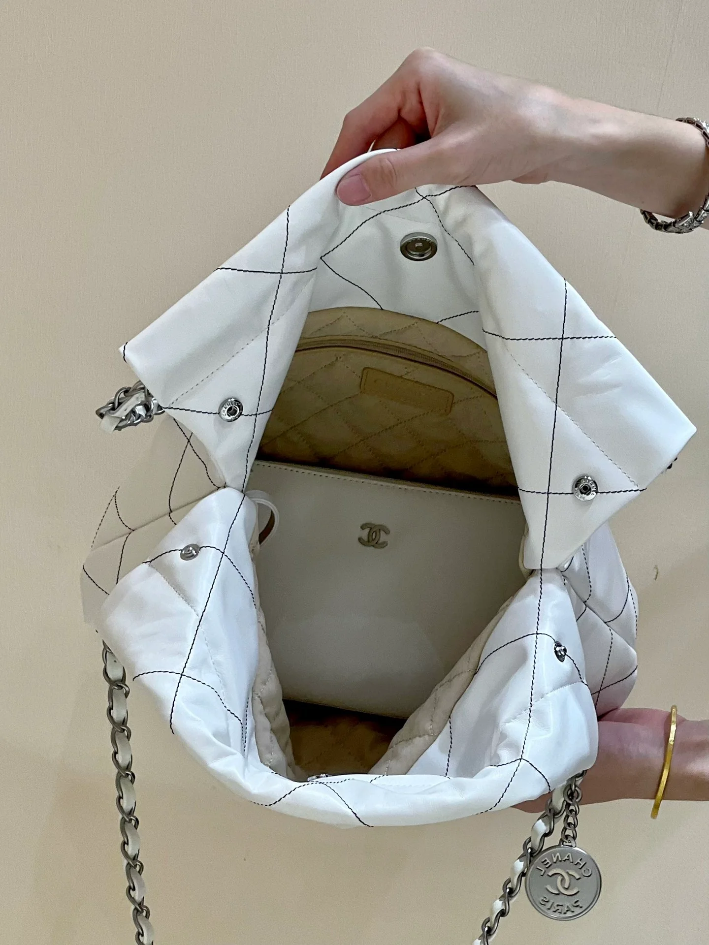 Сумка Chanel из круизной коллекции 2023 года - модель 22bag - белая с черной строчкой.