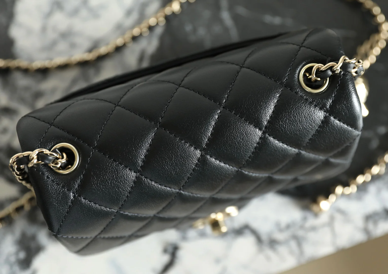 Сумка-шар Chanel из 25-каратного золота с регулируемой застежкой, черная с фурнитурой из светлого золота.