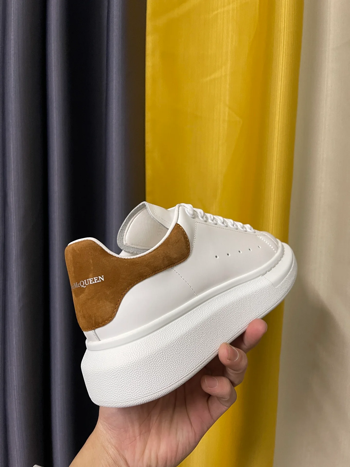Классические белые кроссовки McQueen с коричневой замшевой подошвой на каблуке.