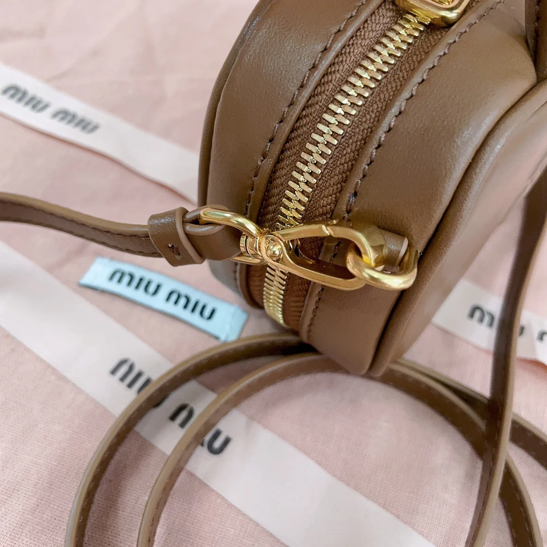 Мини-портфель Miu Miu с брелоком — из телячьей кожи.