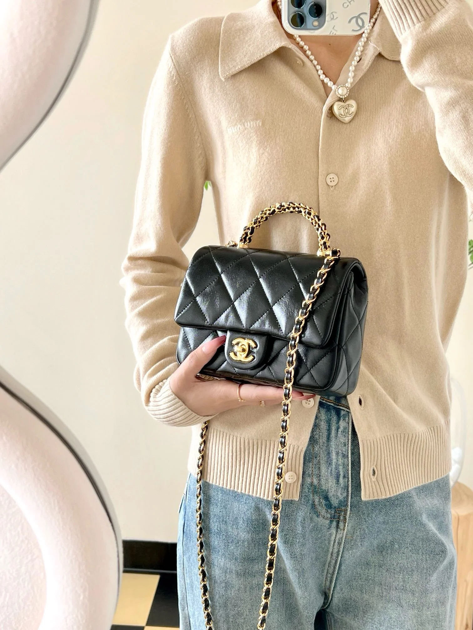 Маленькая черная сумка Chanel с клапаном и поворотной ручкой.