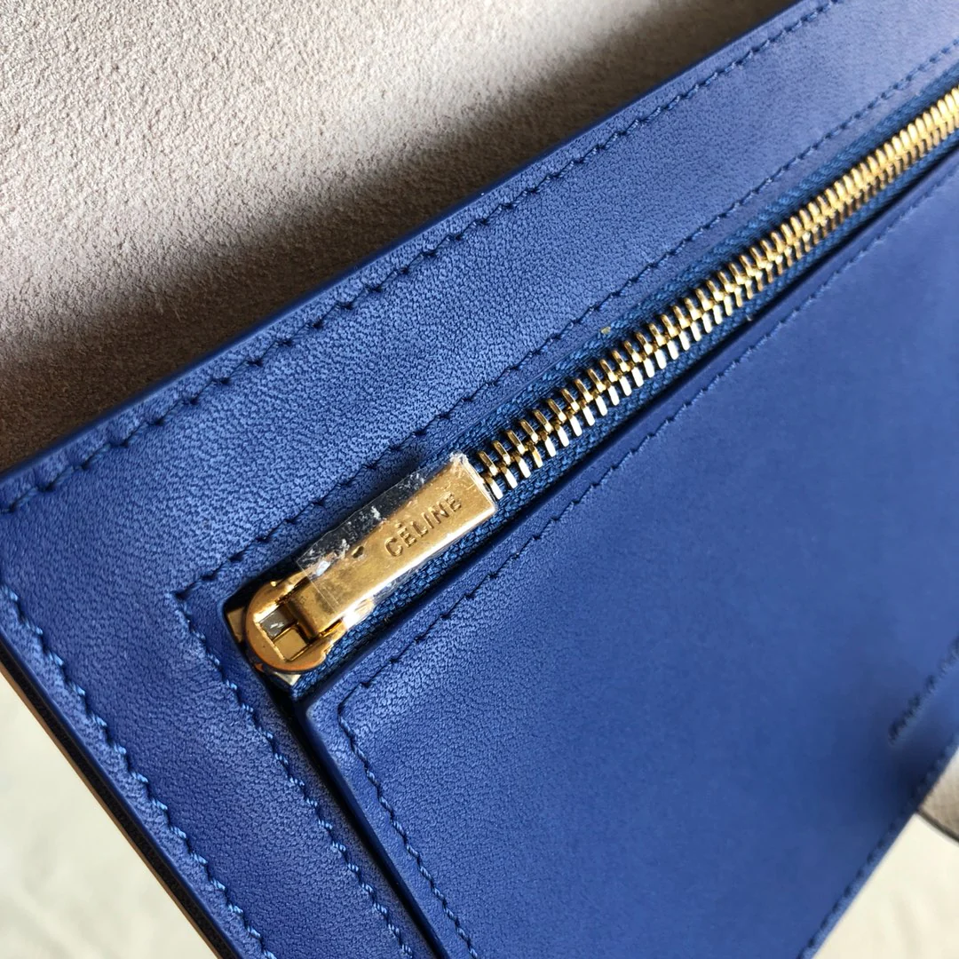 Длинный кошелек Celine — кремовый и синий — с принтом в виде пальмовых листьев.