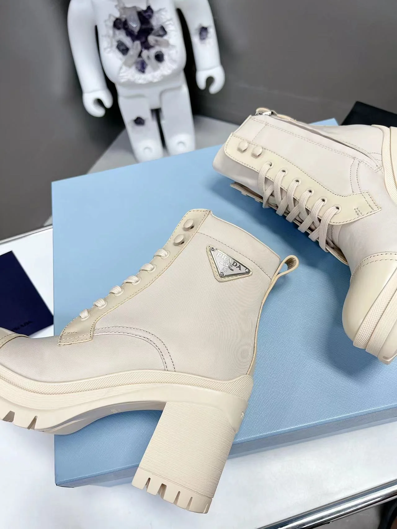 Новинка весны 2022 года от Prada: ботильоны на шнуровке и массивном каблуке — белые.