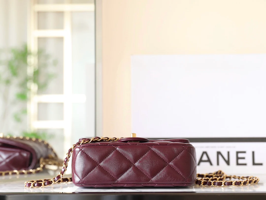 Маленькая бордовая сумочка Chanel с клапаном и привинчивающейся ручкой.