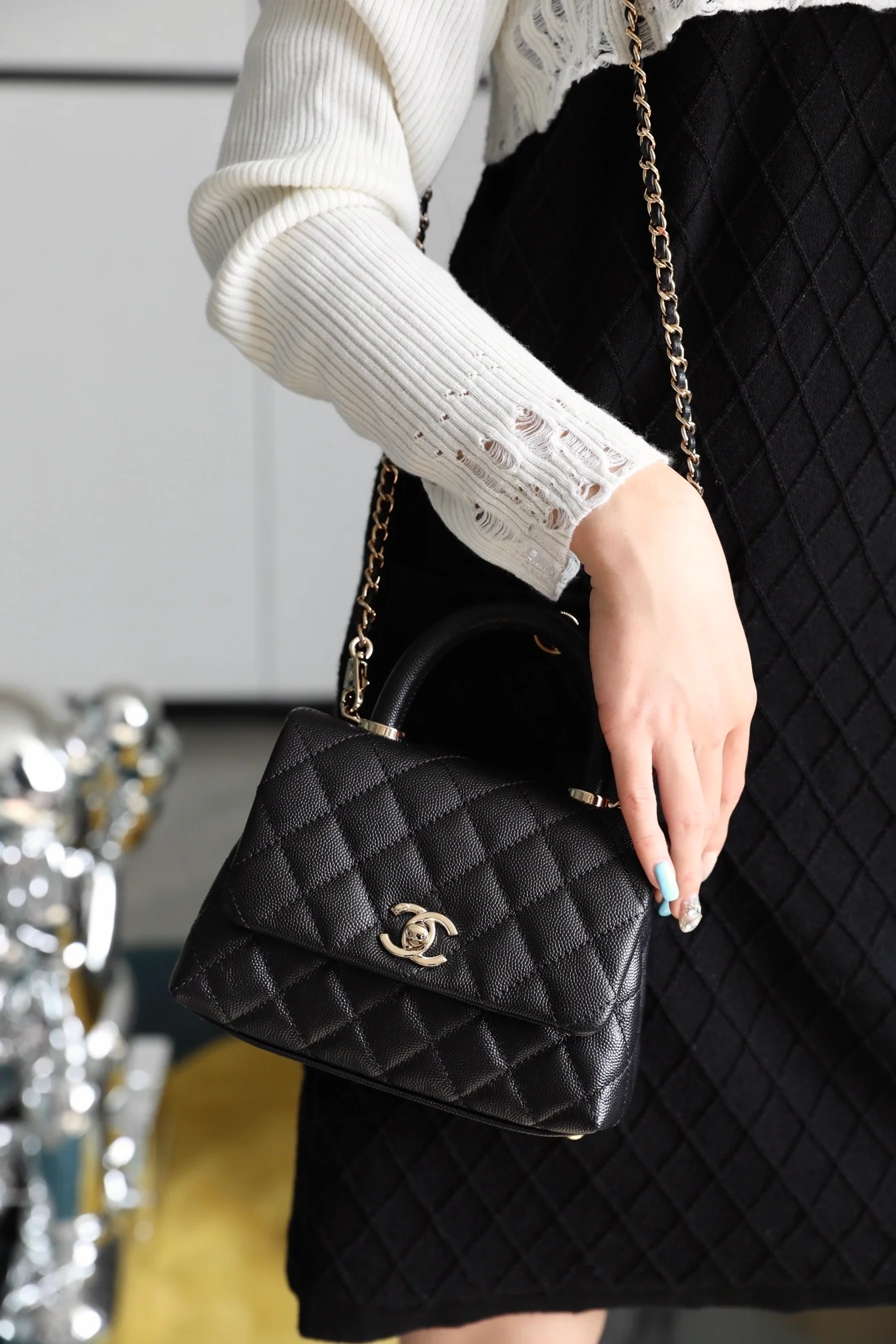 Мини-сумка Chanel Coco Handle — черная кожа с золотистой пряжкой.