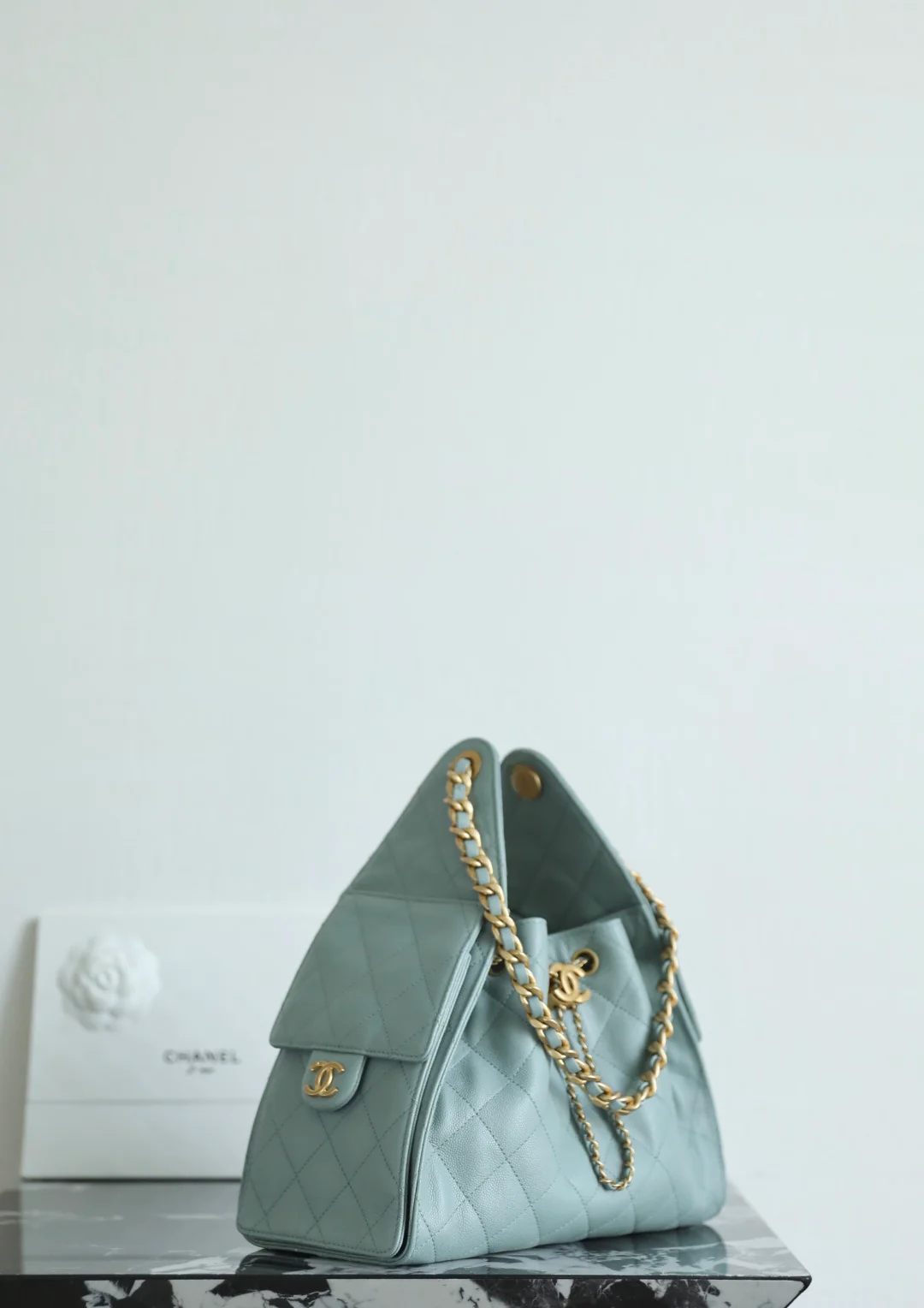 Маленькая сумка-шоппер Chanel — серо-голубая с золотой фурнитурой.