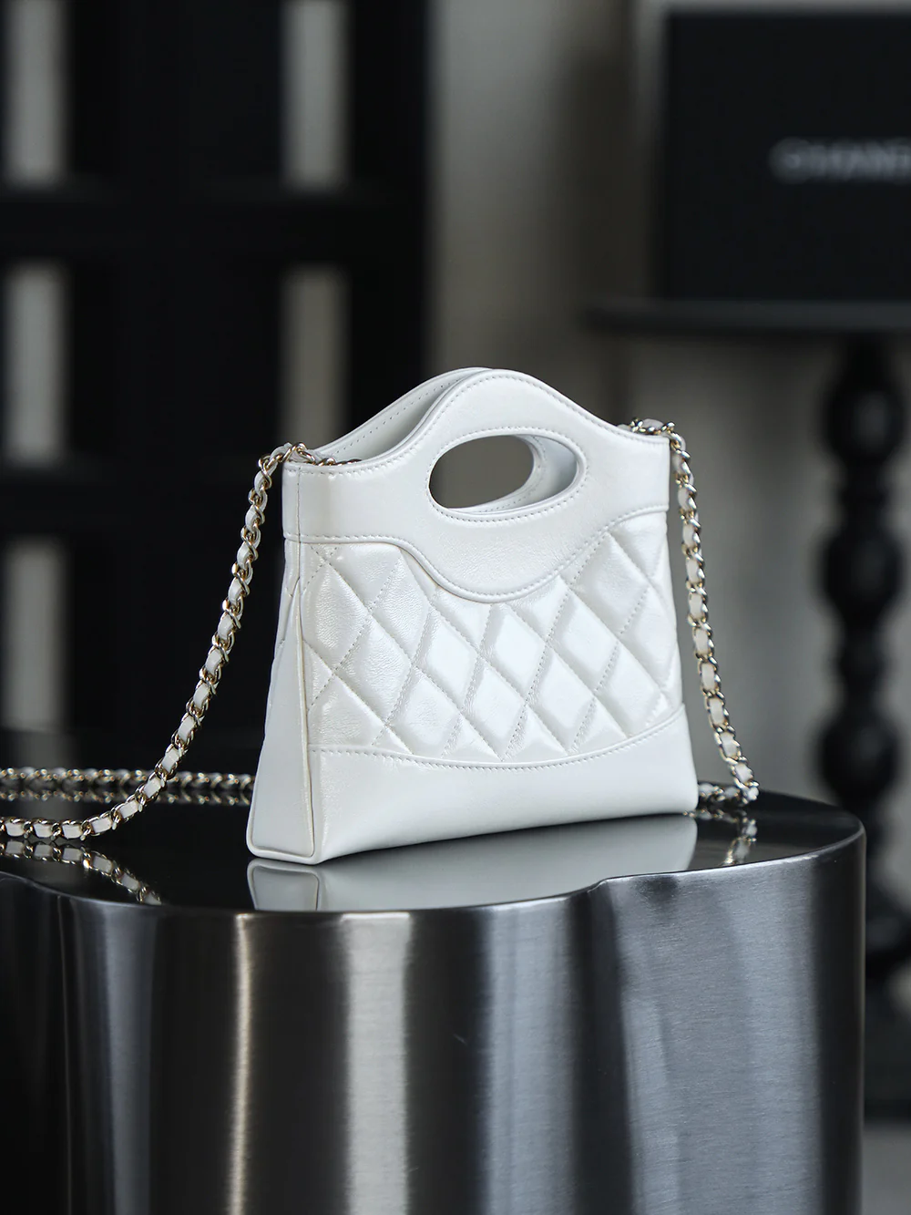 Сумка Chanel Nano 31, горизонтальный вариант, белая с пряжкой из светло-золотистого металла.