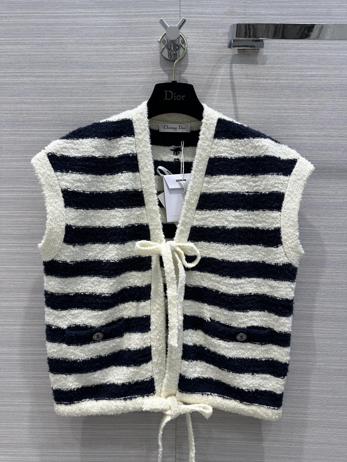 Новинка Dior весна/лето 2024: элегантный вязаный жилет на шнуровке темно-синего и белого цвета.