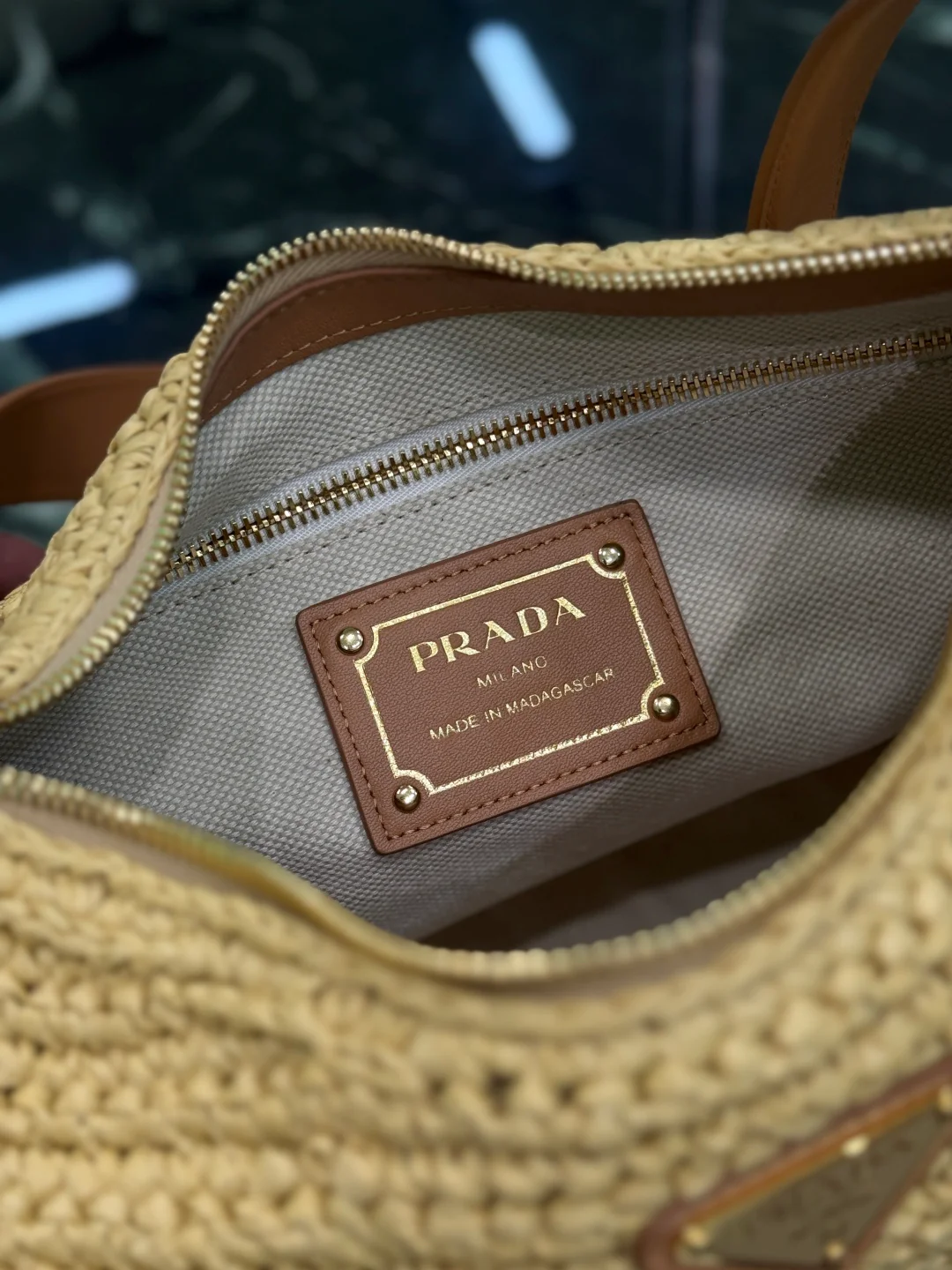 Сумка Prada Aimee из соломы, которую можно носить под мышкой.