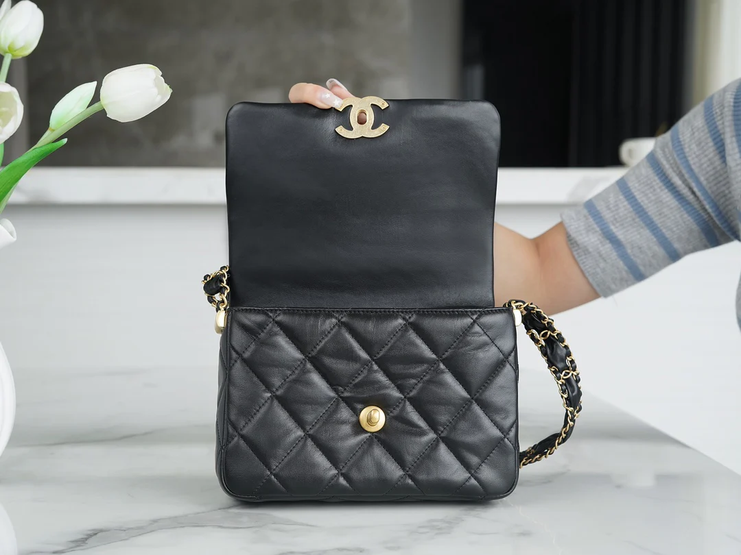 Коллекция Chanel осень/зима - сумка с широким плечевым ремнем и клапаном, черная с золотыми вставками из мятой телячьей кожи.