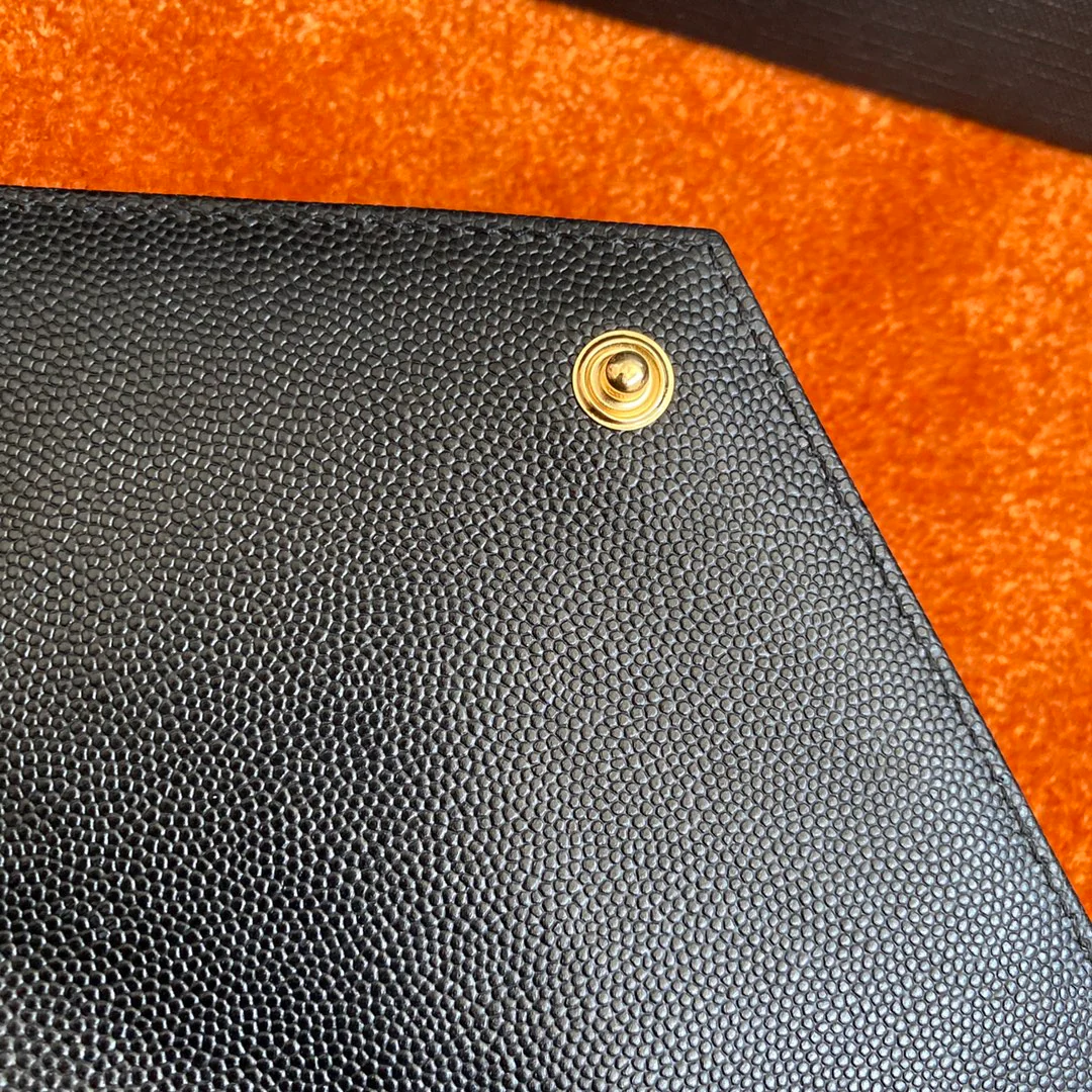 Сумка-конверт YSL с монограммой из икры — черная с золотой фурнитурой.