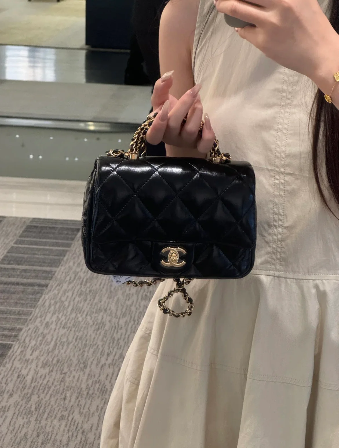 Маленькая черная сумка Chanel с клапаном и поворотной ручкой.