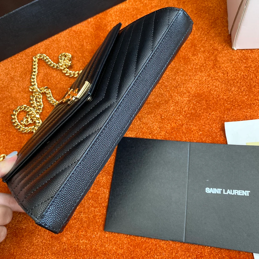 Сумка-конверт YSL с монограммой из икры — черная с золотой фурнитурой.