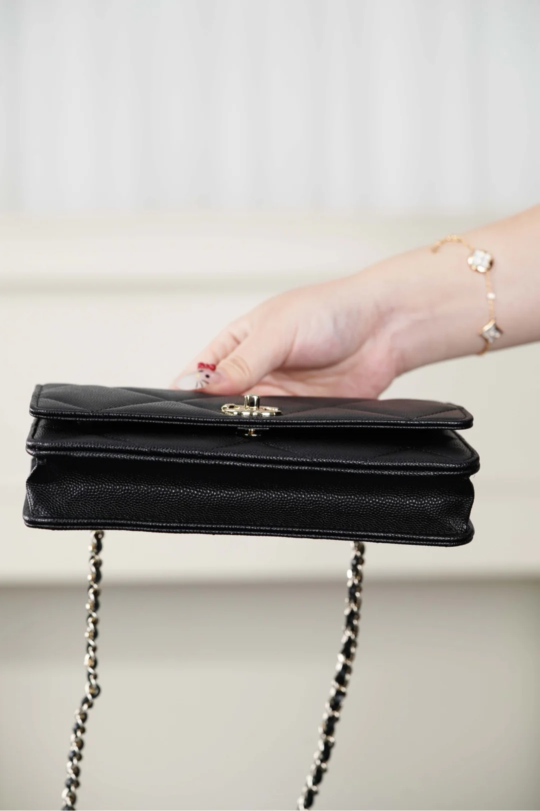 Ручка сумки Chanel из 25-каратного золота с ромбовидным узором, черная сумка-корзина с золотой фурнитурой.