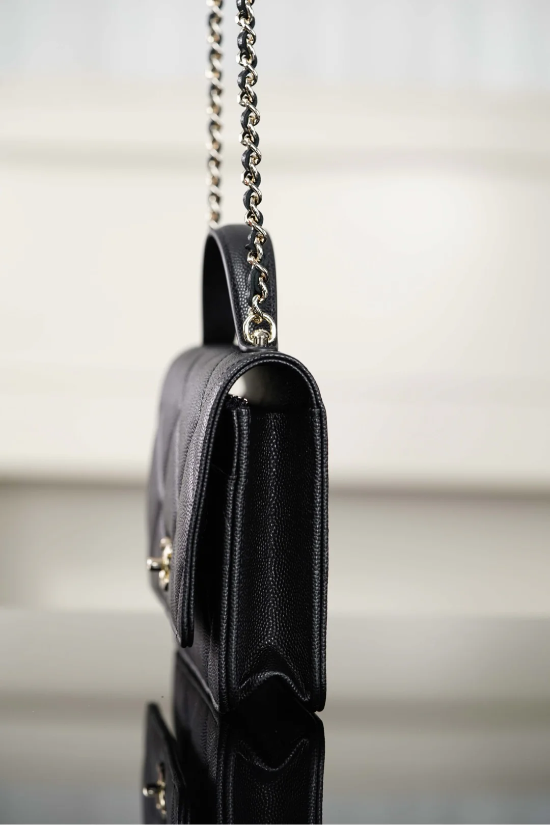 Ручка сумки Chanel из 25-каратного золота с ромбовидным узором, черная сумка-корзина с золотой фурнитурой.