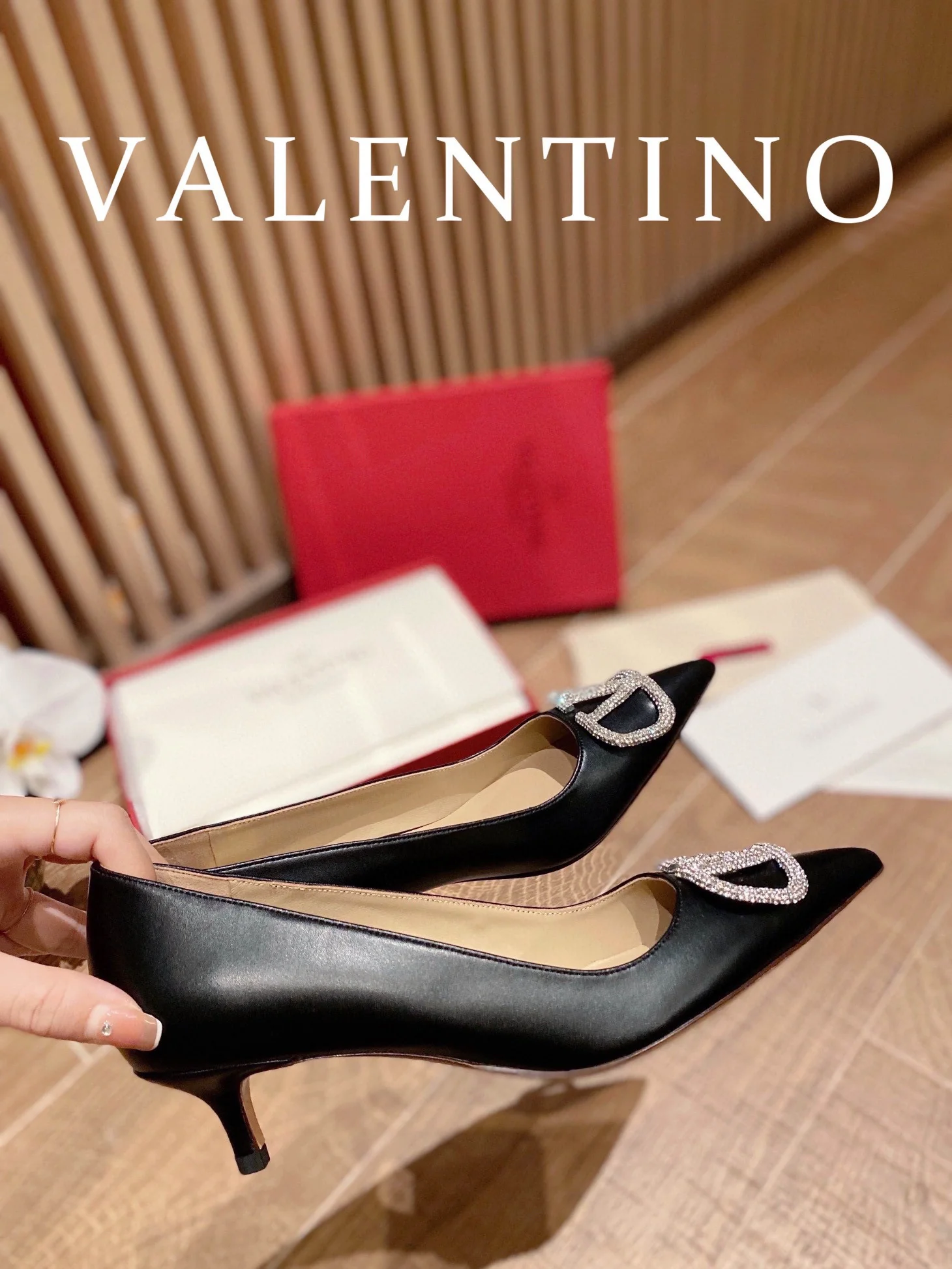 Туфли Valentino на каблуке с V-образным вырезом и бриллиантовой пряжкой — черные.