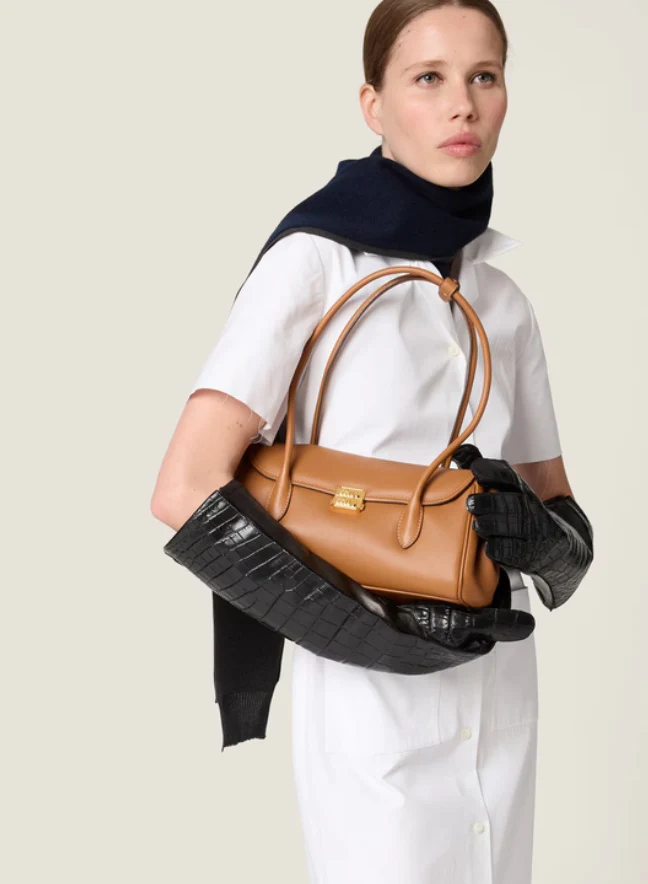 Сумка-багет Miu Miu через плечо — цвет коньяк — фотографии в одежде.