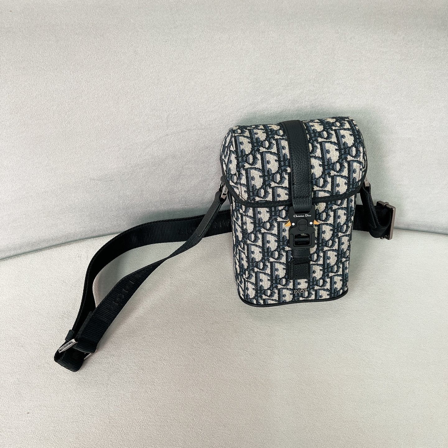 Сумка-мессенджер Dior Hittheroad Straight Flip — черная с зернистой отделкой.