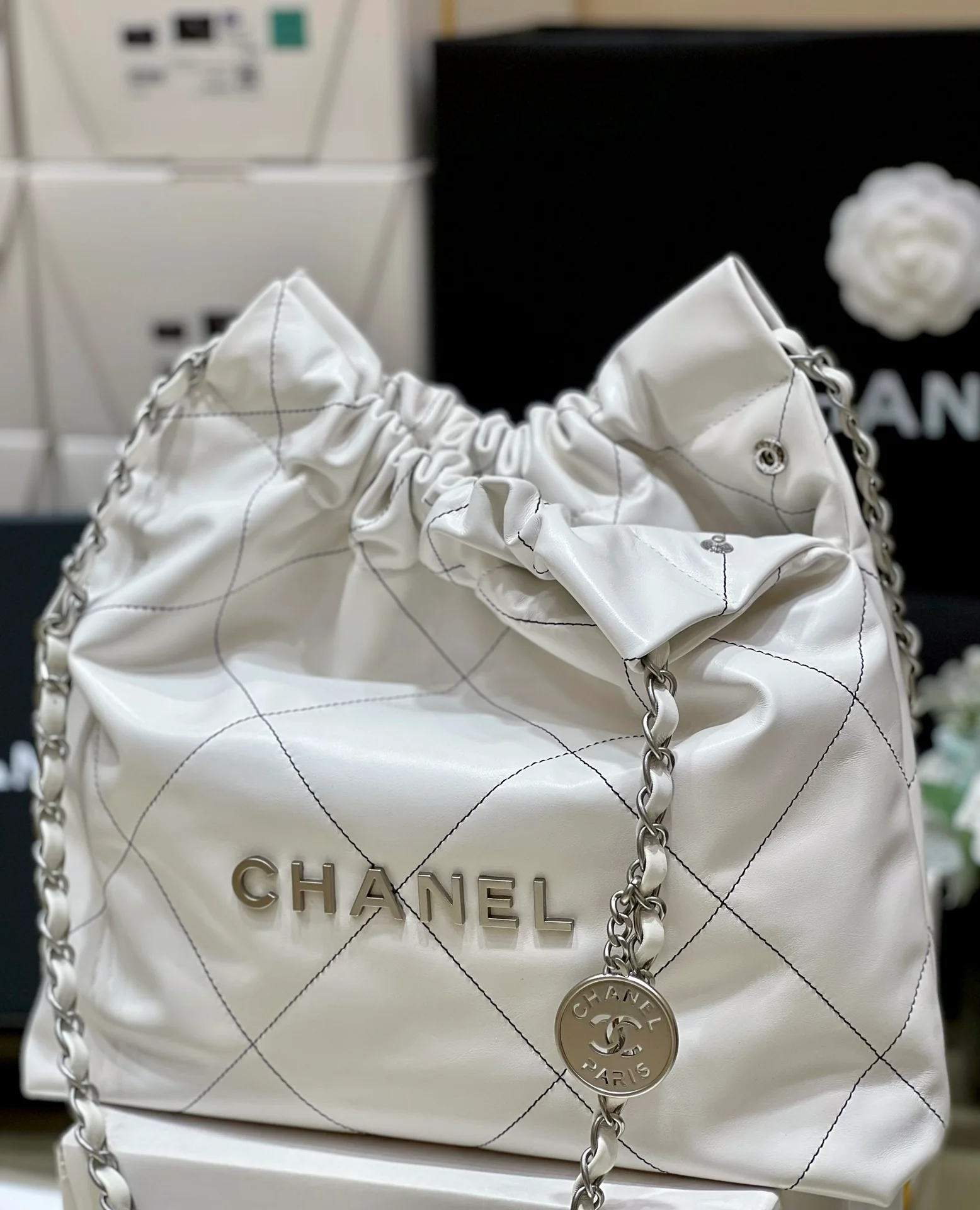Сумка Chanel из круизной коллекции 2023 года - модель 22bag - белая с черной строчкой.