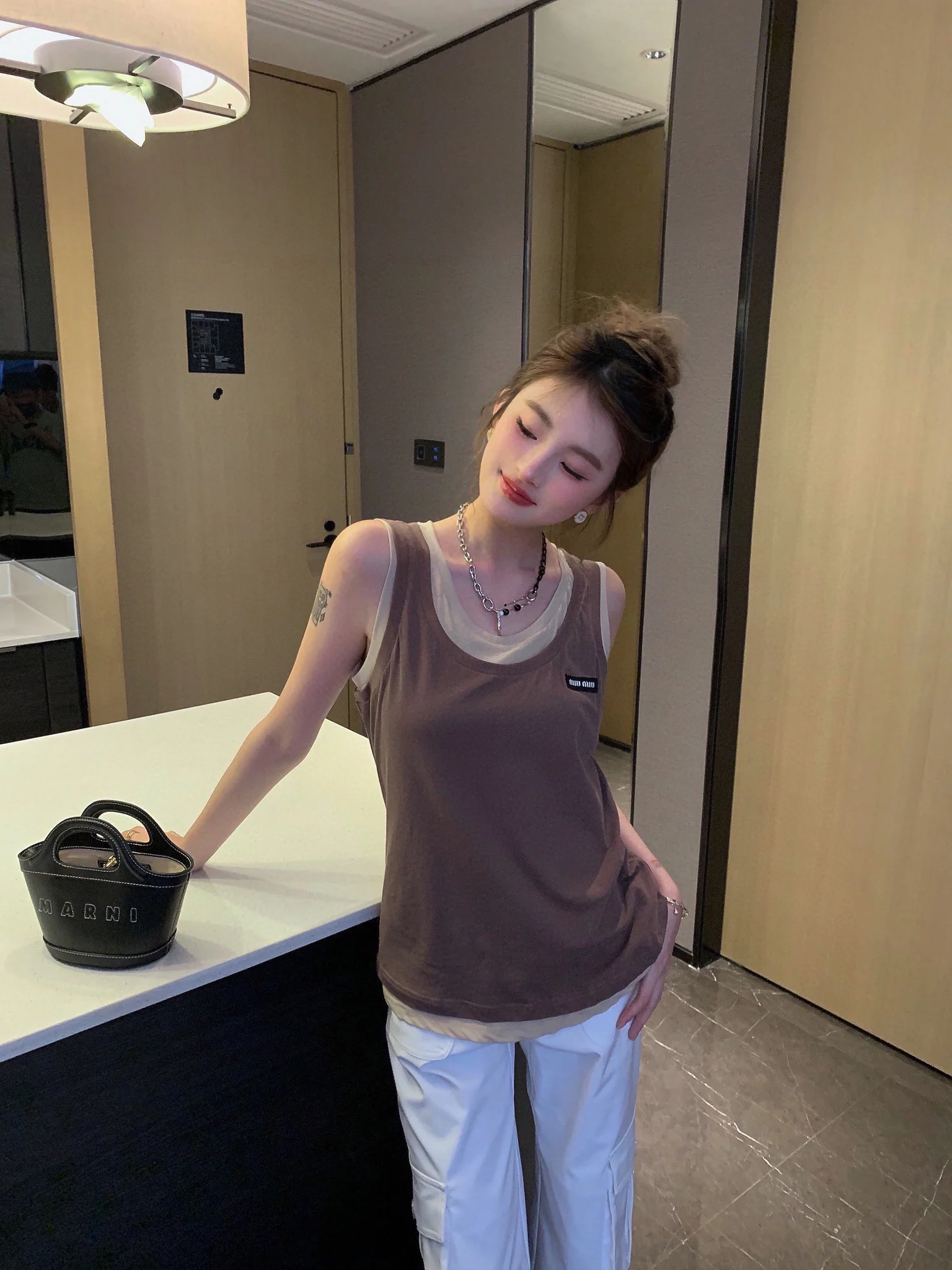 Новинка сезона весна/лето 2024 от Miu Miu: многослойный, культовый универсальный жилет — коричневый.