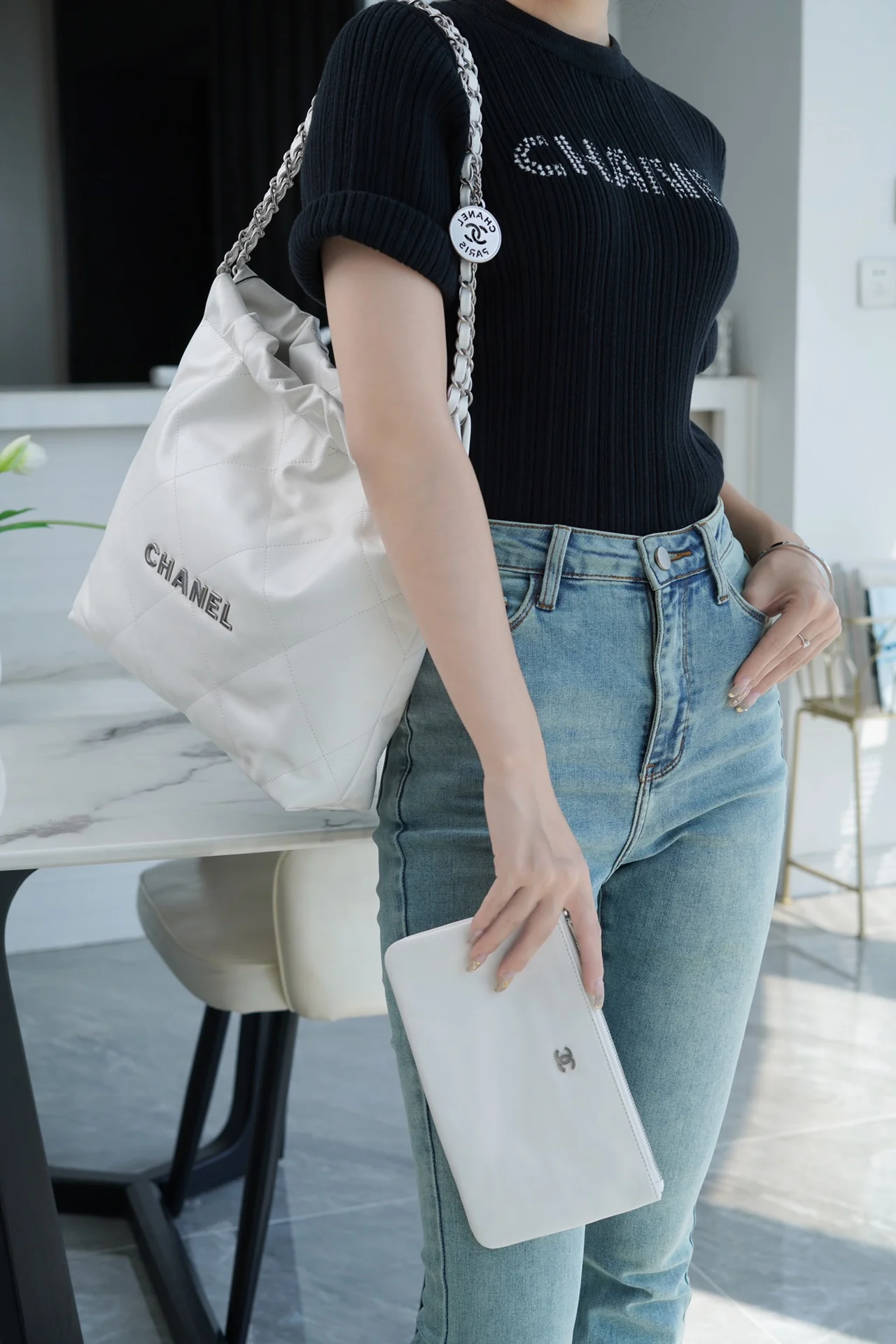 Сумочка Chanel No. 22 — маленькая, белая, серебристая.