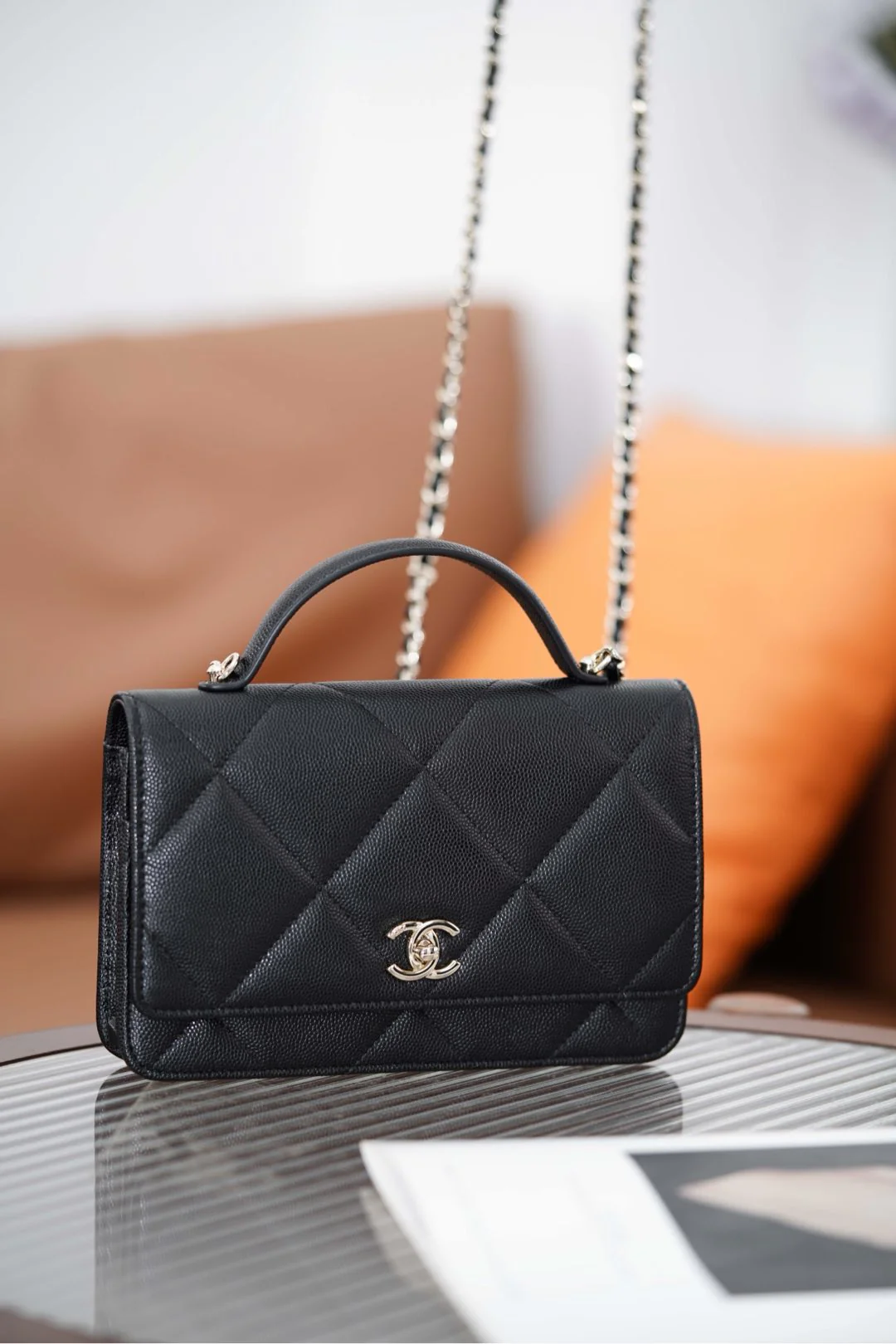 Ручка сумки Chanel из 25-каратного золота с ромбовидным узором, черная сумка-корзина с золотой фурнитурой.