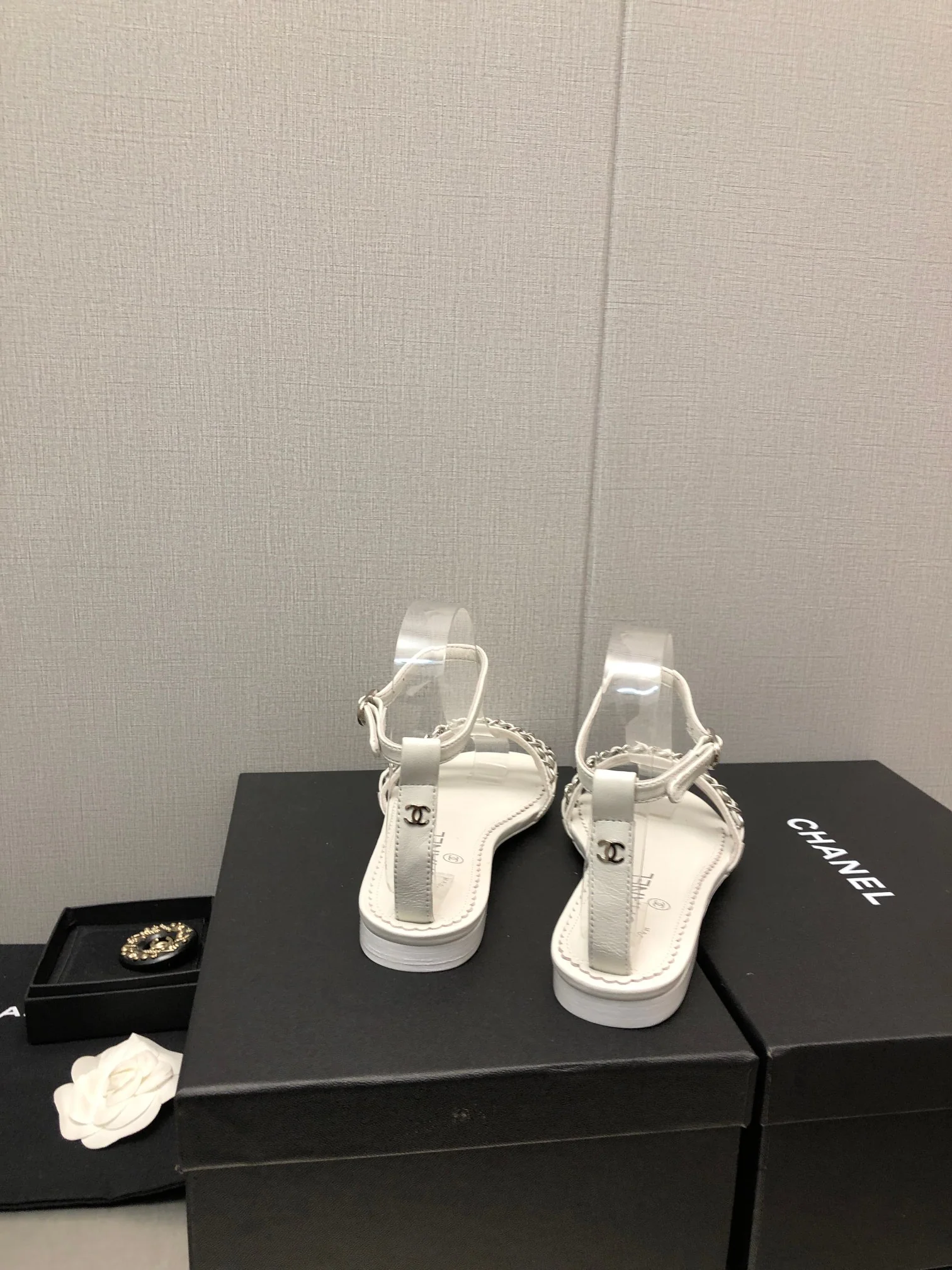 Новинка весны 2023 года от Chanel - сандалии на плоской подошве с цепочкой - белые.
