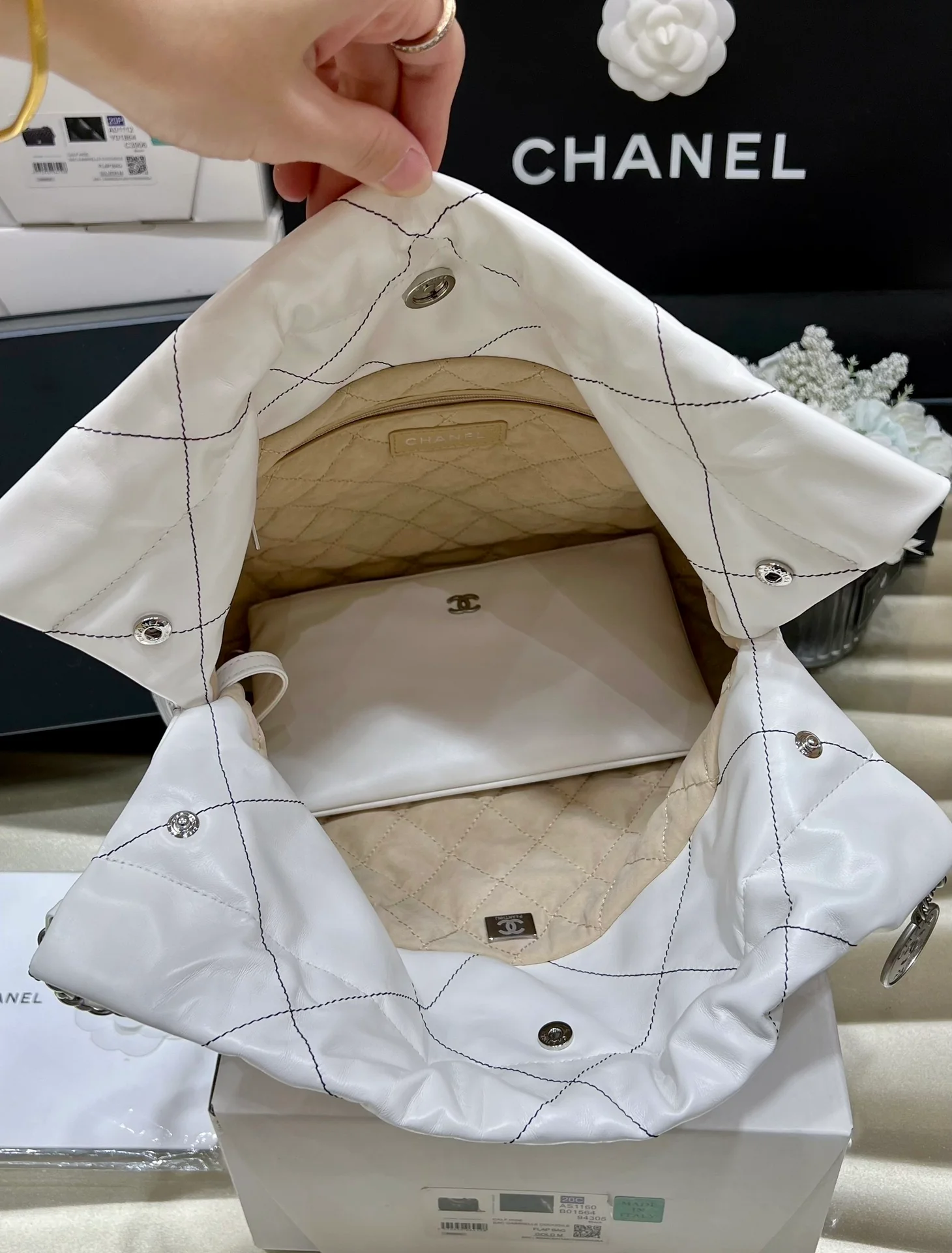 Сумка Chanel из круизной коллекции 2023 года - модель 22bag - белая с черной строчкой.