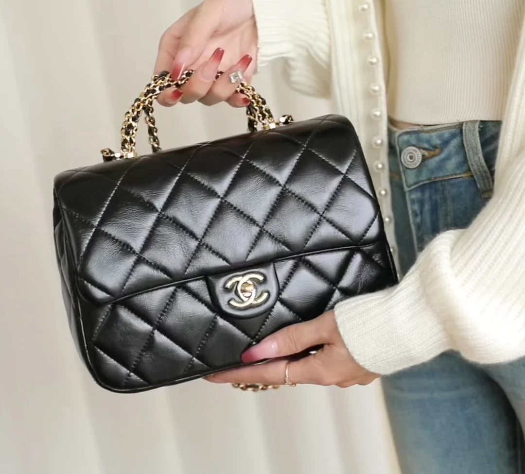 Большая черная сумка Chanel с клапаном и поворотной ручкой.