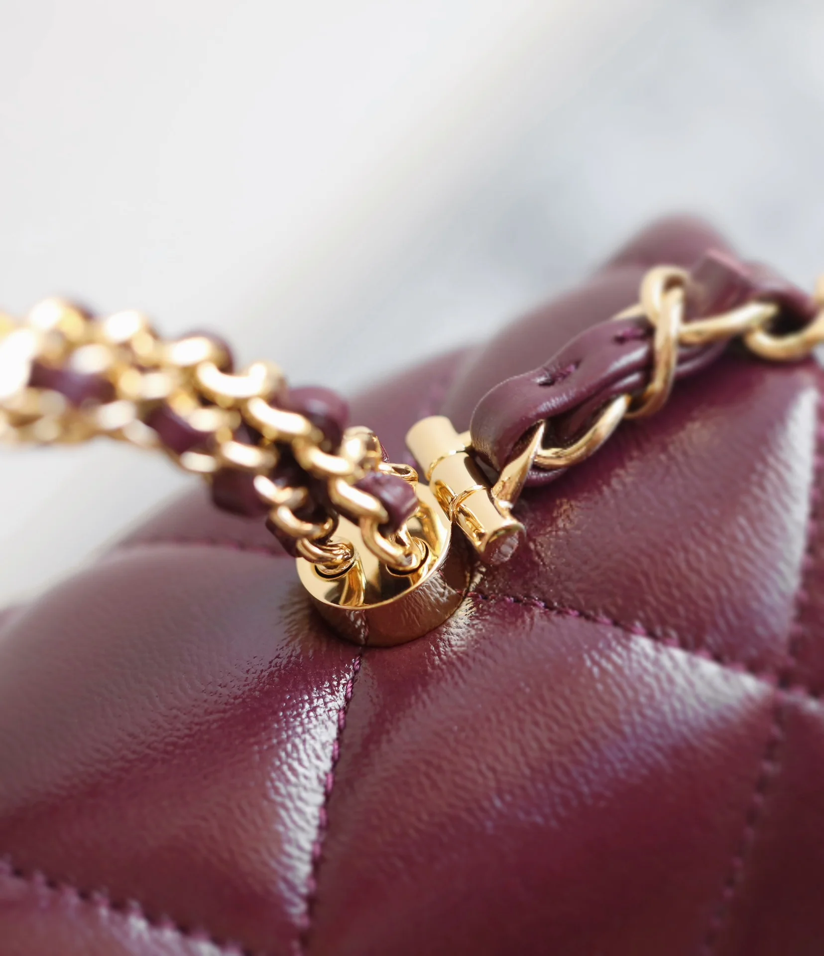 Маленькая бордовая сумочка Chanel с клапаном и привинчивающейся ручкой.